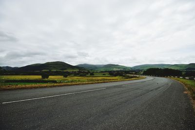 Road by landscape against sky