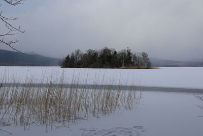 Scenic view of lake against sky during winter