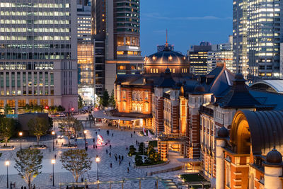 Illuminated buildings in city at dusk