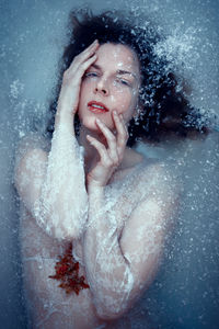 Icy flower - selfportrait - woman in icy water holding a flower in her hands