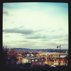 Cityscape against cloudy sky