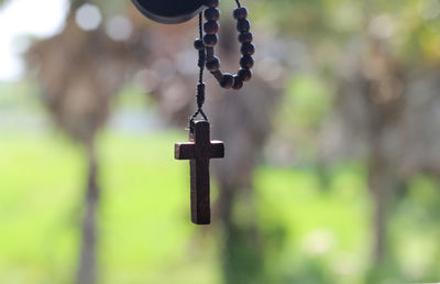Close-up of wooden crucifix hanging on a window