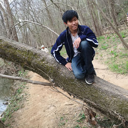 Full length of young man sitting on land