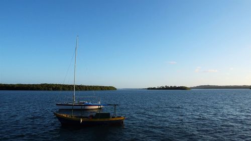 Boat sailing in sea against clear sky