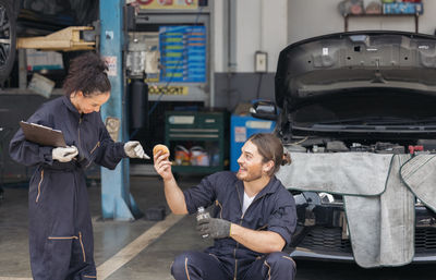 Happy couple taking their car for service and waiting relax time at garage