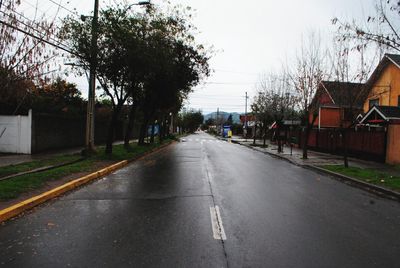 Empty road along buildings