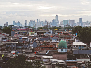 High angle view of cityscape against cloudy sky