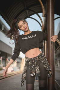 Beautiful young woman standing at railroad station