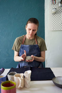 Young woman making pottery on table in workshop