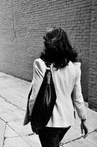 Young woman standing by wall