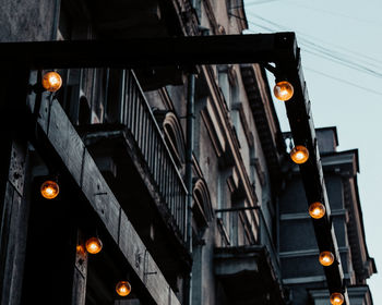 Low angle view of illuminated street light against building at night