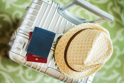 High angle view of hat and passport on luggage