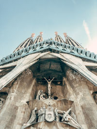 Low angle view of statues on building against sky