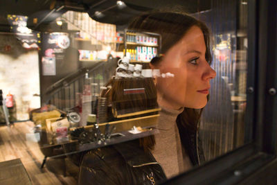 Portrait of woman looking through glass window