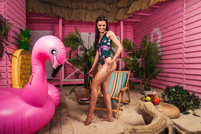 Portrait of smiling young woman with pink umbrella