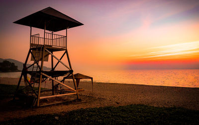 Lifeguard station over the seacoas with sunset on the beach, evening time