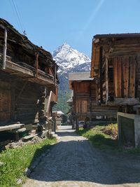 Houses by snowcapped mountains against clear sky