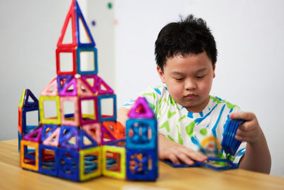 Boy playing with toy blocks on table