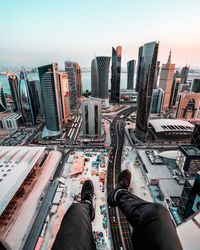 Low section of man sitting on terrace against cityscape