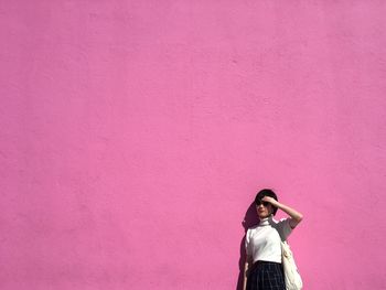 Woman by a pink wall