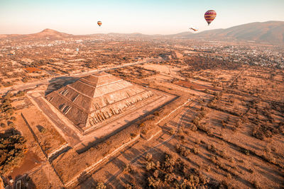 Aerial view of hot air balloons flying over landscape