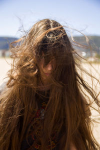 Portrait of girl with tousled hair while standing at beach