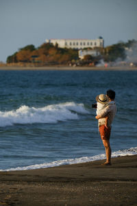 Side view of woman standing at beach