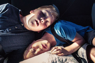 High angle view of brothers sleeping in car