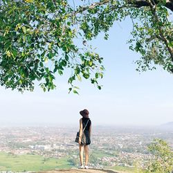 Woman standing on tree trunk
