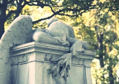 Statue against sky in cemetery