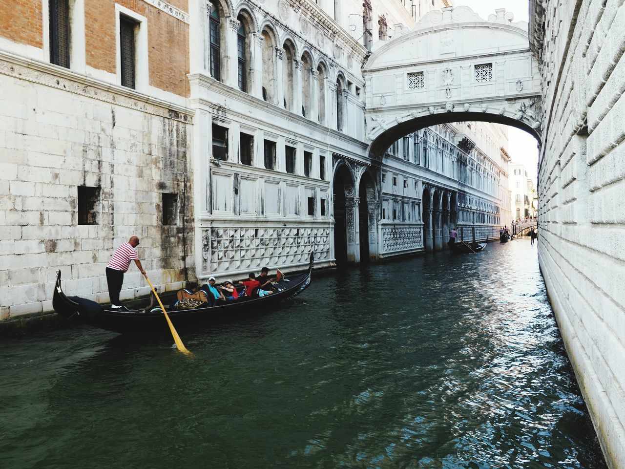 PEOPLE IN CANAL BY BUILDING