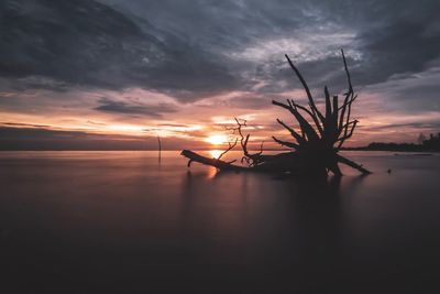 Scenic view of sea against dramatic sky during sunset