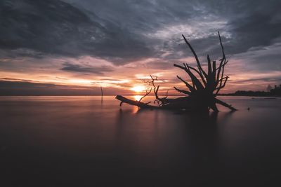 Scenic view of sea against dramatic sky during sunset