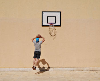 Full length of man playing basketball