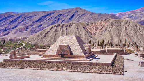 Built structure on landscape against mountain range