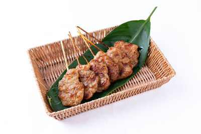 High angle view of meat and leaves on white background