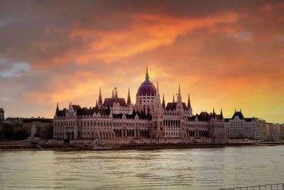 Scenic view of old building in town against cloudy sky