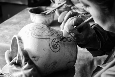 Cropped hands of craftsperson making clay product in pottery workshop