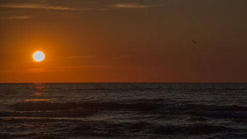 Scenic view of sea against orange sky