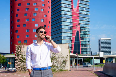 Portrait of handsome young man smiling while using a mobile phone