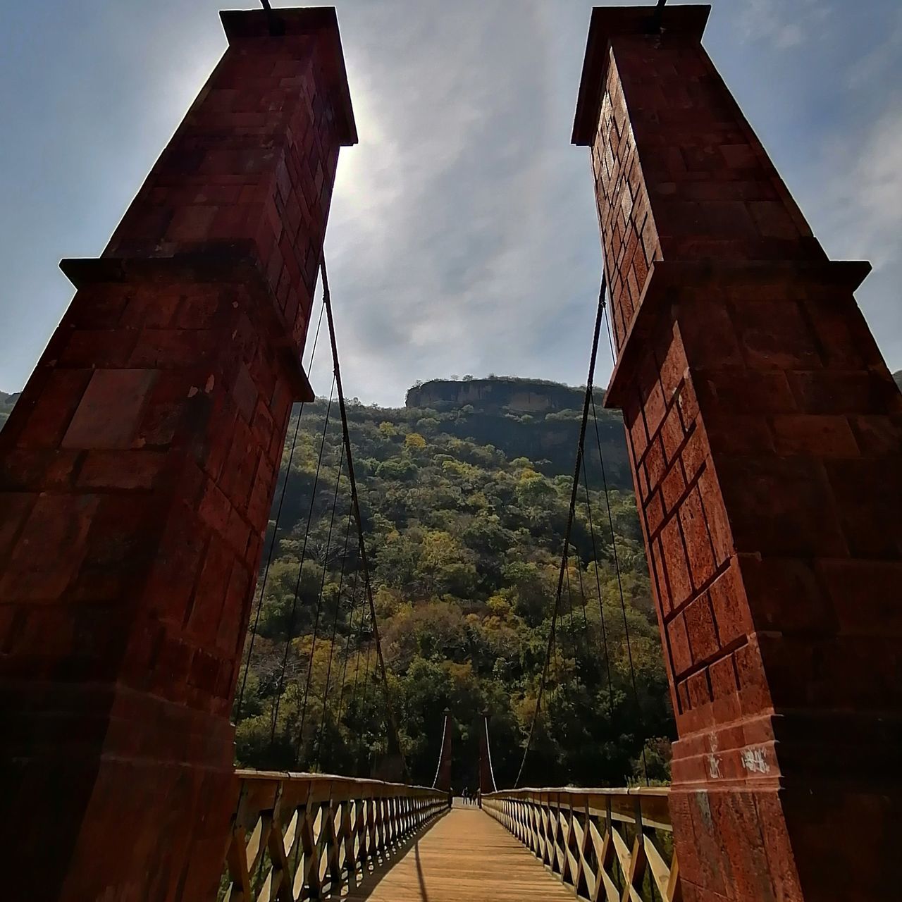 LOW ANGLE VIEW OF BRIDGE BY BUILDING AGAINST SKY