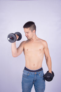 Full length of shirtless man against white background