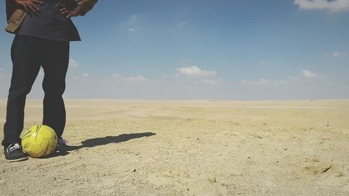 Low section of man standing on beach