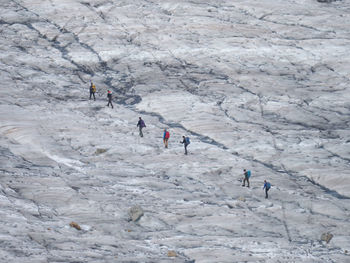 High angle view of people walking on snow covered mountain