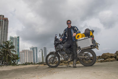 Man posing next to his adventure motorbike after a long trip, columbia