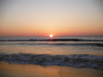 Scenic view of sea against orange sky