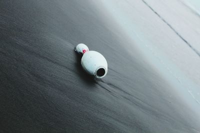Close-up of bowling pin on sand