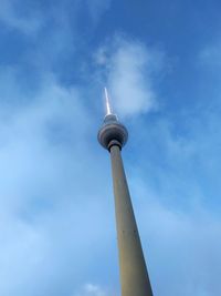 Low angle view of communications tower against cloudy sky