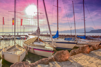 Sailboats moored in sea against sky