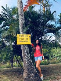 Full length portrait of young woman with palm trees
